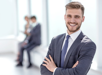 successful businessman on the background of a bright office. - obrazy, fototapety, plakaty
