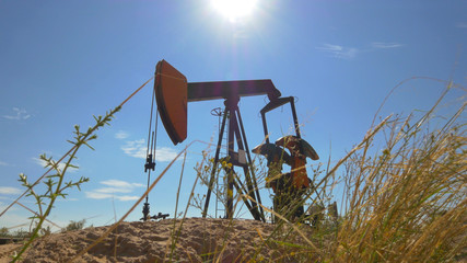 Naklejka premium Industrial jack pump platform working on oil field in Texas