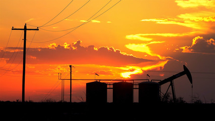 Oil pump jack containers and electrical wiring at amazing golden sunset © helivideo