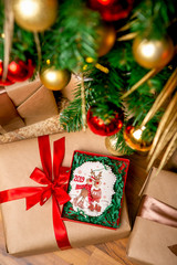 Cookie with deers and numbers 2019 in carton box on a gift box near the decorated fir tree, top view. Holiday sweets. New Year's and Christmas theme. Festive mood. Christmas Card