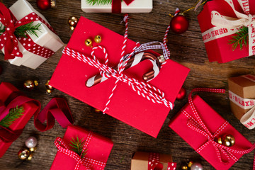 Christmas gift giving concept - christmas presents in red and white boxes on wooden table, flat lay top view scene