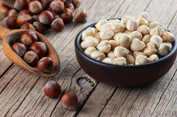 Hazelnuts, filbert in burlap sack and in bowl near wooden shovel on brown vintage table. heap or stack of hazelnuts. Hazelnut background, healty food