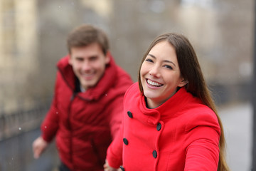 Fototapeta premium Happy couple in red running outdoors in winter