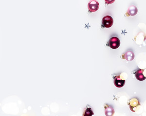 Christmas flat lay scene with pink abd violet glass balls and gift box, copy space on white desk