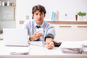 Man under stress measuring his blood pressure