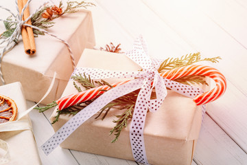 Gift boxes wrapped in wrapping paper with ribbons on a white wooden background