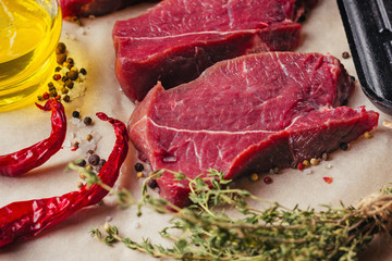 Fresh raw beef meat steak slices with spices and olive oil ready for cooking