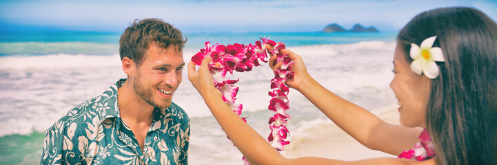 Hawaii woman giving lei flower garland welcoming tourist man on Hawaiian beach. Portrait of a Polynesian culture tradition of giving a flower necklace to a guest as a welcome gesture. Banner panorama. © Maridav