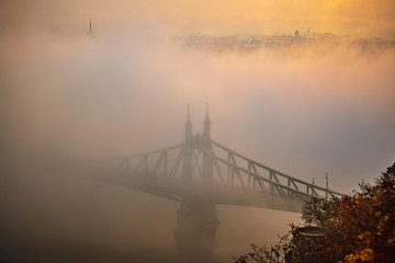 Budapest, Hungary - Mysterious foggy sunrise with Liberty Bridge (Szabadsag hid) and hazy skyline of Budapest at autumn morning