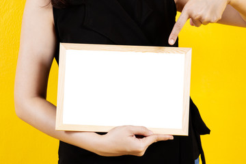 Asian girl in the black cloth holding a wooden white board close up.
