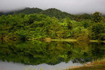 Beautiful landscape of peaceful lake and mountain in deep jungle in Thailand after the rain.