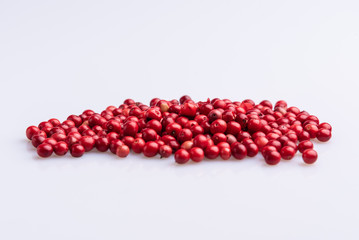 Pile of Pink Pepper, Brazil Pepper, Rose pepper, Schinus terebinthifolius seeds over white background