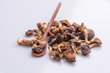 Dehydrated shimeji with a wooden spoon, dried mushrooms on white background, top view, copy space, soft light
