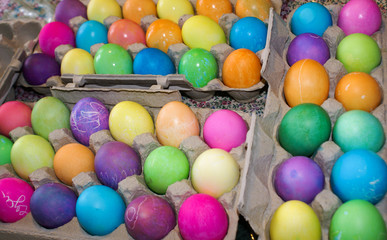 Many colorful freshly dyed easter eggs drying in egg cartons for Easter