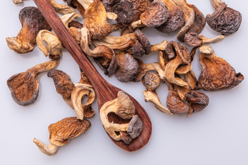 Dehydrated shimeji with a wooden spoon, dried mushrooms on white background, top view, copy space, soft light