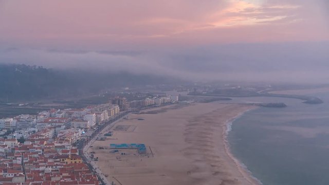 View of Nazare panorama with cabins of Funicular timelapse. Fog coming from ocean at evening during sunset.