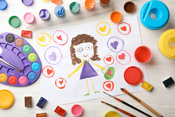 Flat lay composition with child's painting of girl on table