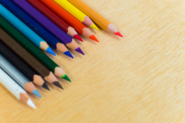 Obraz premium Aligned colored pencils on top left close up