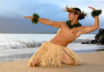 Male Hula Dancer performs on the beach a traditional masculine hula. 