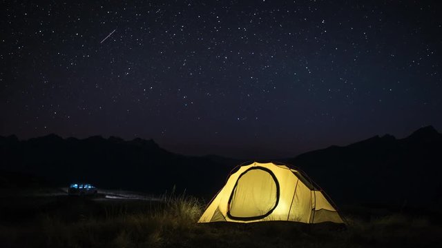 Time Lapse of Camping with a car, tent and campfire at night