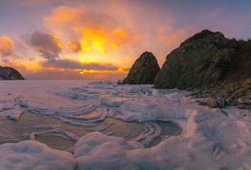 Fototapeta na wymiar Sunset on the sea, winter, snow, ice and rocks
