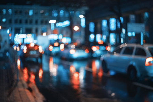 Blurred city at night. Bokeh. Beautiful abstract scene with defocused buildings, cars, city lights, people. Colorful bokeh background with urban night scene. Design. Concept backdrop. Vintage