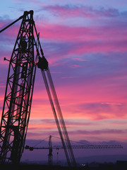 Two Building Crane Silhouetted During Cloudy Sunset