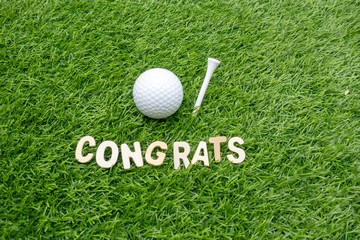 Congratulations to golfer with golf ball and tee on green grass 