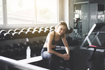 Fit asian woman sitting and relax after the training session in gym,Concept healthy and lifestyle,Female taking a break after exercise and workout,Happy and smile