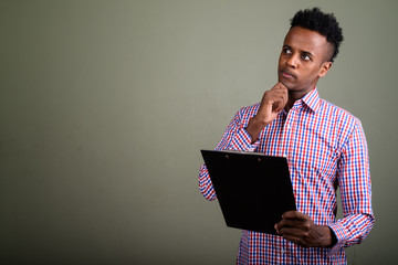 Young handsome African businessman against colored background