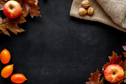 Autumn Nature Concept. Background With Autumn Symbols. Brown Leaves, Nuts And Apple On Black Background Top View Copy Space Frame