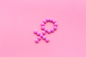 Obraz na płótnie Canvas Female diseases. Female gender icon symbol made of pills on pink background top view space for text