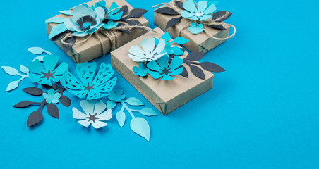 Gift box wrapped in craft paper blue background.