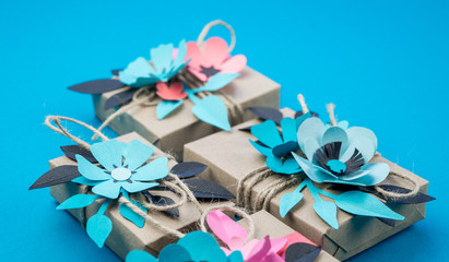 Gift box wrapped in craft paper blue background.