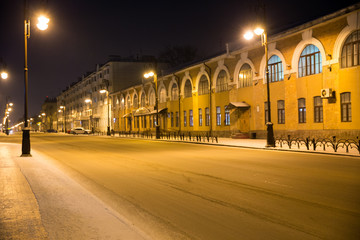 Fototapeta na wymiar Bright lights on a snowy street. Quiet winter night