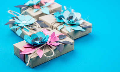 Gift box wrapped in craft paper blue background.