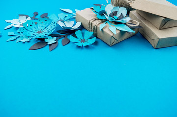 Gift box wrapped in craft paper blue background. Copy space