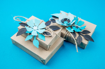 Gift box wrapped in craft paper blue background.