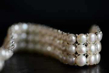 White pearl necklace on a dark background close up