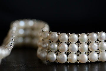 White pearl necklace on a dark background close up