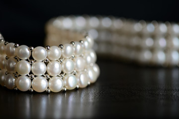 White pearl necklace on a dark background close up