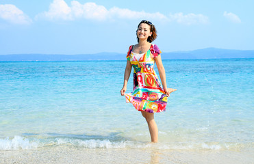 リゾートのビーチでほほ笑む若い女性