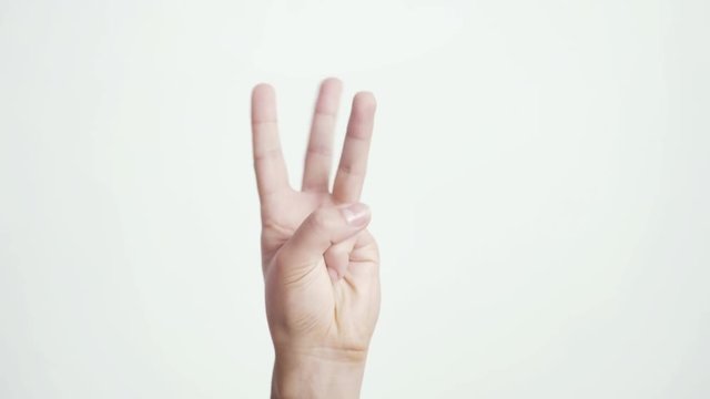 Close up of isolated female hand shows fist fist, then one, two, three, four, five fingers female hand counting from 0 to 5 on white background. 3840x2160