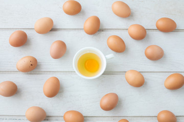 white kitchen table texture background with fresh yellow yolk egg on white cup. view from top table.