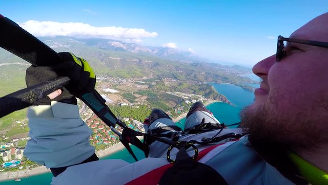 Man flying on paraplane in sky, clouds and skyline landscape. Point of view paraglider flying on paraplane. Parachuting, parachuting concept. Active sport and extreme hobby.