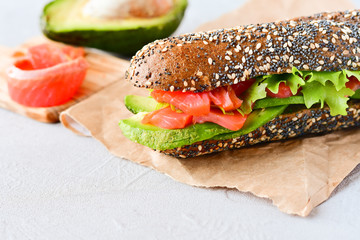 gluten-free multi grain bread sandwich with salmon, avocado and lettuce, healthy diet concept, selective focus