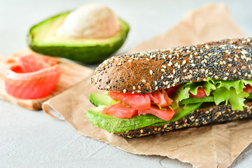gluten-free multi grain bread sandwich with salmon, avocado and lettuce, healthy diet concept, selective focus