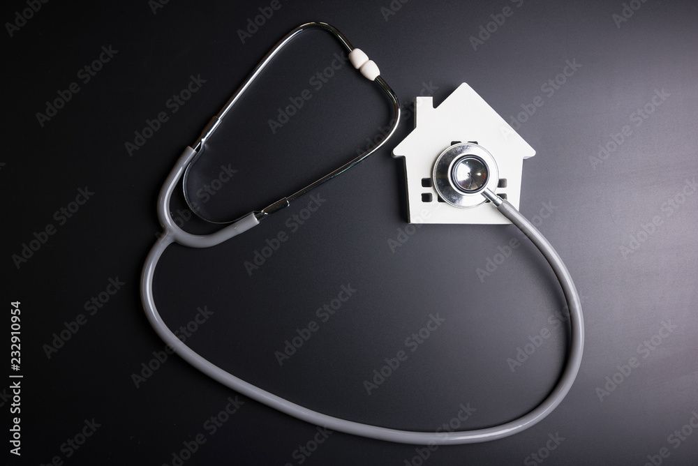 Wall mural house model with stethoscope isolated on black background.indicates the health of the house.