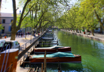 Fototapeta na wymiar Annecy, France - April 21, 2011: View of river and boats from Pont des Amours (Bridge of Love) in Annecy France. Annecy is a commune in the Haute Savoie department of the Rhone-Alpes.