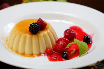 vanilla pudding with berries and cream